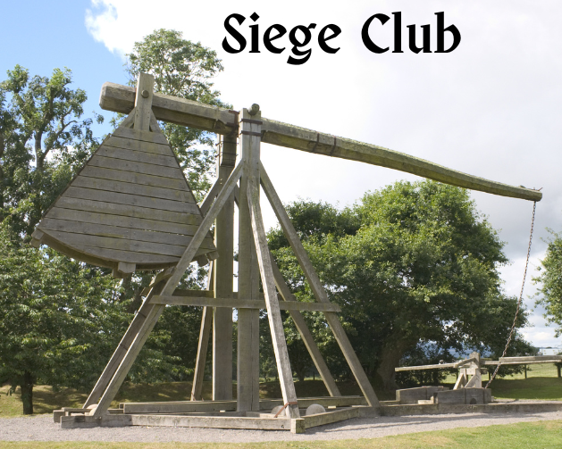 Photo image of a medieval catapult with trees in the background.